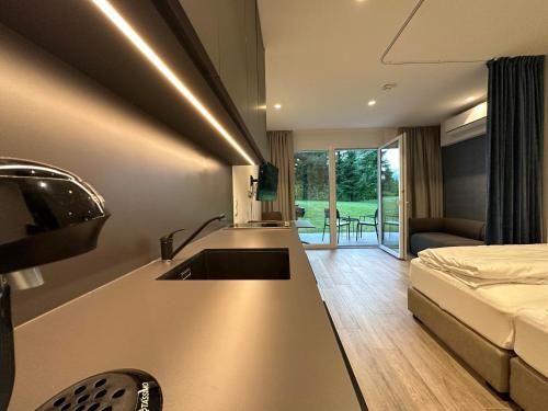 a kitchen with a sink and a bed in a room at Casa Grande in Techelsberg am Worthersee