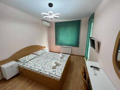 a small bedroom with a bed and a green window at Апартамент за гости ТРАПЕЗИЦА МАК in Veliko Tŭrnovo