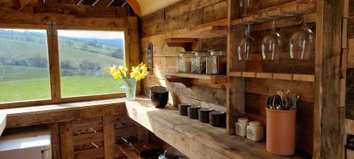 吉斯本的住宿－Little Middop Farm Camping Pods，厨房设有窗户和带瓶子的柜台。