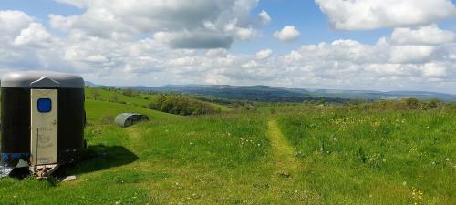a field of grass with a small building in the middle at Little Middop Farm Camping Pods in Gisburn