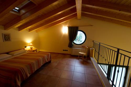 1 dormitorio con cama y ventana grande en Agriturismo Il Melograno en Villafranca di Verona