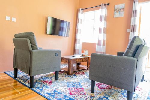 a living room with two chairs and a table at Golden Palms Apartment in Kingstown