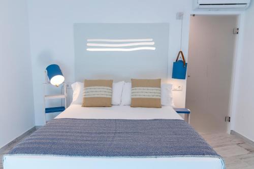 a blue bedroom with a bed with two pillows at Hostal Boutique La Mar Serena in Peñíscola