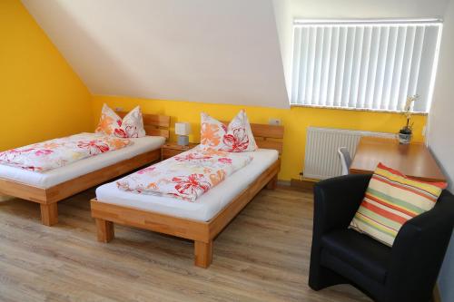ein kleines Zimmer mit 2 Betten und einem Stuhl in der Unterkunft Ferienwohnung "Am Eisenbühl" in Berg