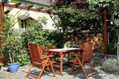 a wooden table and two chairs in a garden at Ferienwohnung "Am Eisenbühl" in Berg