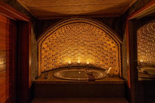 a bathroom with a bath tub with candles in it at Mont Eco Game Reserve in Montagu
