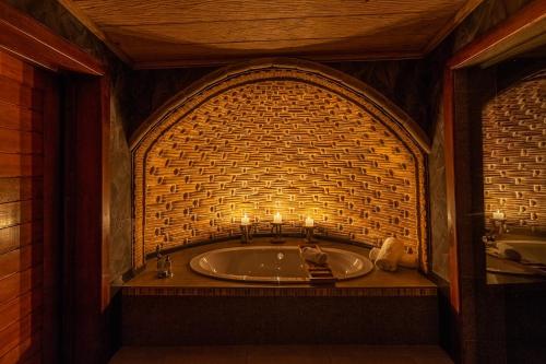 Un baño con bañera y velas. en Mont Eco Game Reserve, en Montagu