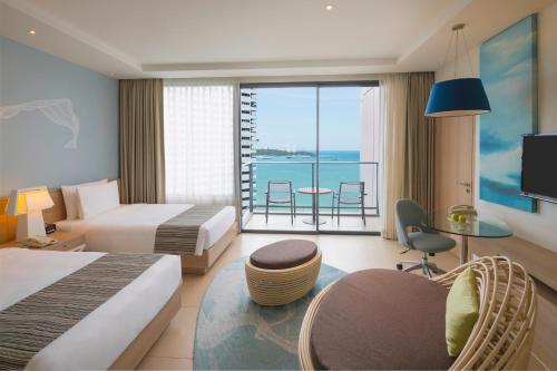 a hotel room with two beds and a view of the ocean at Holiday Inn Pattaya by IHG in Pattaya Central