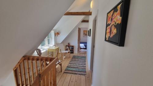 an attic hallway with a staircase with a painting on the wall at Bjørnø Vingård B&B - bed&bath in Bjørnø By