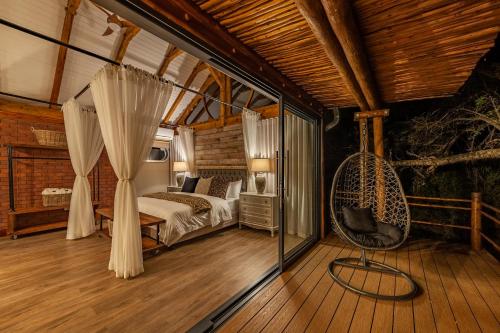 a bedroom with a bed and a swing on a wooden floor at Mont Eco Game Reserve in Montagu