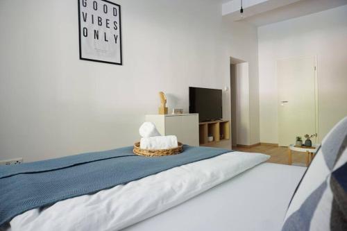 um quarto com uma cama com um cobertor azul e uma televisão em Südstadt-Apartment im Herzen von Paderborn em Paderborn