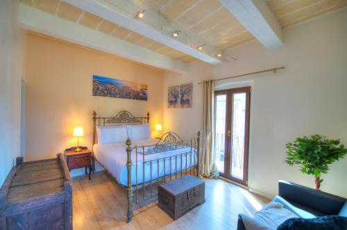 ein Schlafzimmer mit einem Bett und ein Wohnzimmer mit einem Sofa in der Unterkunft Comfy 1 bedroom - Sun terrace & sea views GBUH1-1 in Valletta