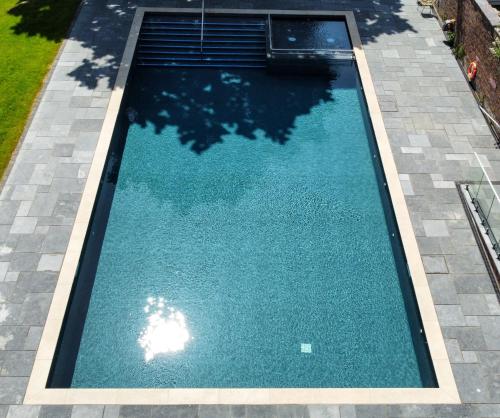una piscina de agua azul en un patio en Coed Helen Holiday Park en Caernarfon