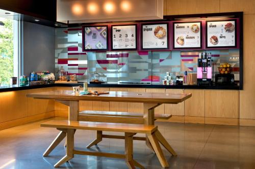 a restaurant with a table and benches in front of a counter at Aloft Chicago O'Hare in Rosemont