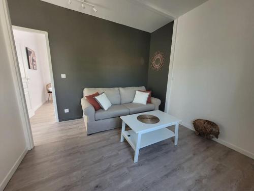 ein Wohnzimmer mit einem Sofa und einem Tisch in der Unterkunft Petit pavillon cosy avec extérieur in Mèze
