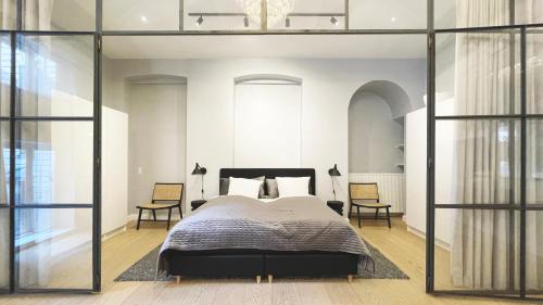 a bedroom with a large bed and two chairs at Unique 3 Bedroom Flat in Vibrant Frederiksberg in Copenhagen