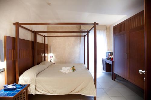 sypialnia z łóżkiem z baldachimem w pokoju w obiekcie Hotel Canguro w mieście San Benedetto del Tronto