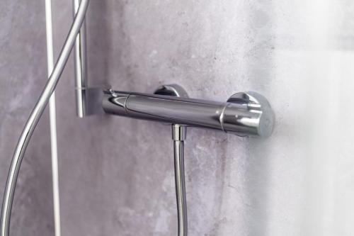 a metal shower door handle on a wall at Hökis-Zimmervermietung 4 in Brande-Hörnerkirchen