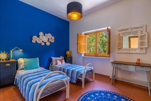 1 dormitorio con paredes azules, 1 cama y ventana en Villa Cuore Verde by Perle di Puglia, en San Cataldo