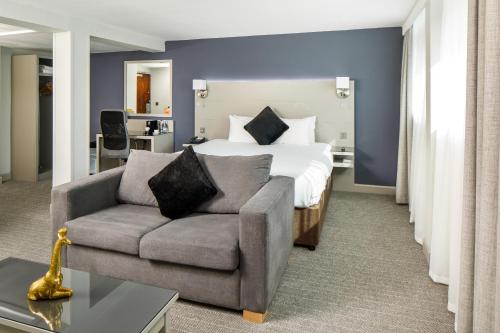 a hotel room with a bed and a couch at Mercure Manchester Piccadilly Hotel in Manchester