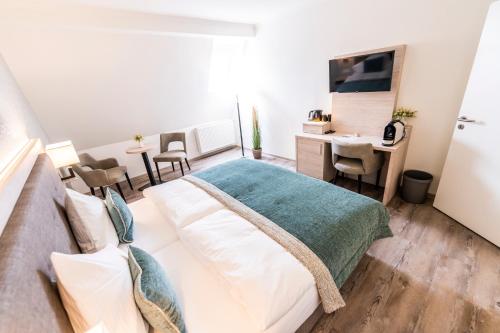 Dormitorio con cama, escritorio y TV en Hökis-Zimmervermietung 4, en Brande-Hörnerkirchen