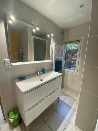 une salle de bain avec un lavabo blanc et un miroir dans l'établissement Bella Vita Brando, à Brando