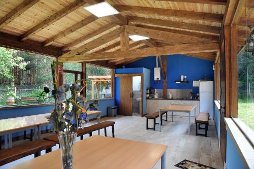 a kitchen and dining room with blue walls and wooden ceilings at LA CABAÑA DE SARA in Vinuesa