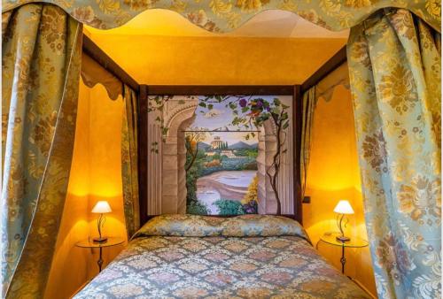 a bedroom with a canopy bed with a painting on the wall at I Segreti del Borgo in Penna in Teverina
