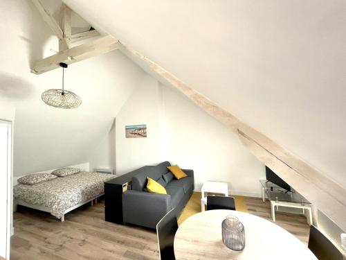un salon avec un canapé et un lit dans l'établissement Les 4 saisons Honfleur - Studio 4, à Honfleur