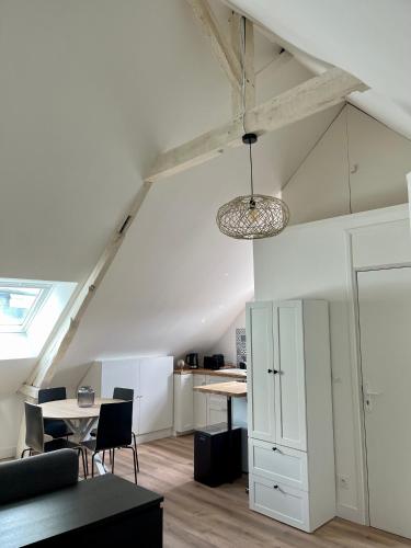 un salon avec une table et des chaises et un plafond dans l'établissement Les 4 saisons Honfleur - Studio 4, à Honfleur