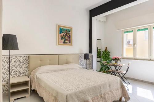 biała sypialnia z łóżkiem i stołem w obiekcie A Casa Da Mami w mieście Piano di Sorrento