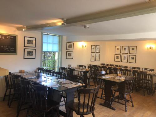 ein Zimmer mit Tischen und Stühlen in einem Restaurant in der Unterkunft The Crown Inn Smallburgh in Smallburgh