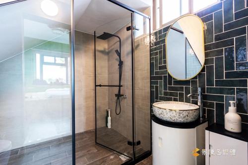 a bathroom with a shower and a sink and a mirror at Jieyuan Homestay in Jian