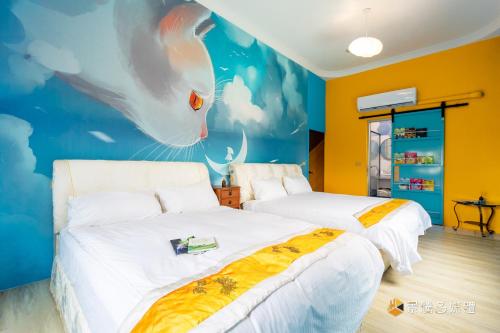 a bedroom with two beds and a cat mural at Jieyuan Homestay in Jian