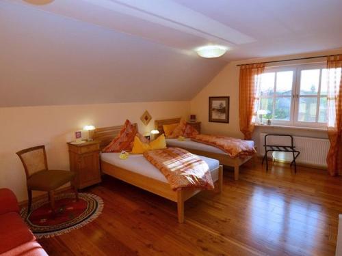 1 Schlafzimmer mit 2 Betten, einem Tisch und einem Stuhl in der Unterkunft Ferienwohnung am Wanderweg in Aidhausen