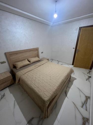 ein Schlafzimmer mit einem Bett in einem Zimmer mit Marmorböden in der Unterkunft Apartment Nador Jadid Hay Al Matar Appart 009 in Nador