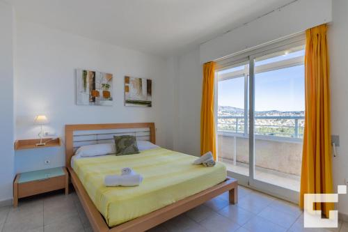 sypialnia z łóżkiem i dużym oknem w obiekcie Apartamento Apolo XVI 67 - Grupo Turis w mieście Calpe