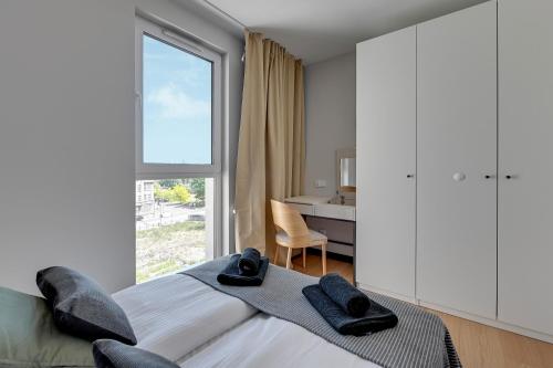 a bedroom with a bed and a window and a desk at Luxury Aura 40 - 6 by Grand Apartments in Gdańsk