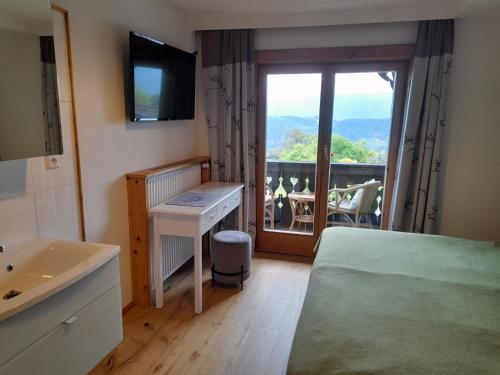 a room with a bed and a sink and a window at Haus Hanshois in Millstatt