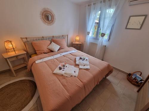 una camera da letto con un grande letto con due asciugamani di Villa de charme Mas de la Cigaline & chambres d'hôtes chez Dany 83 a Garéoult