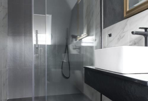 a bathroom with a glass shower and a sink at Prinz Gregor in Braşov