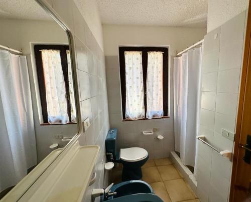 y baño con aseo, lavabo y espejo. en I bilocali di via Ginestre, Rena Majore, en Rena Majore