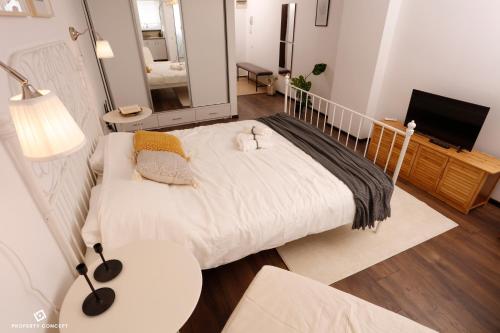a bedroom with a large bed and a living room at Elegant Concept Studio in Bucharest