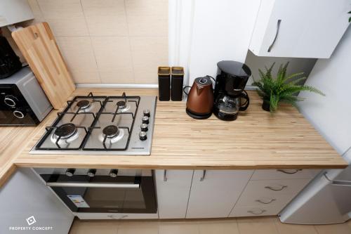 a small kitchen with a stove top on a wooden counter at Elegant Concept Studio in Bucharest