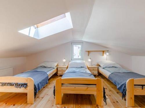 a attic bedroom with three beds and a skylight at Pokoje gościnne Kolc in Jastarnia