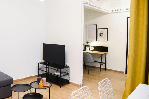 雅典的住宿－Dado's Apartment，客厅配有电视和桌椅