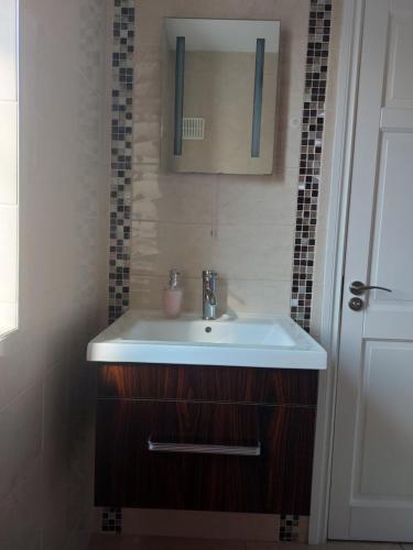 een badkamer met een wastafel en een spiegel bij Grá na Farraige in Enniscrone
