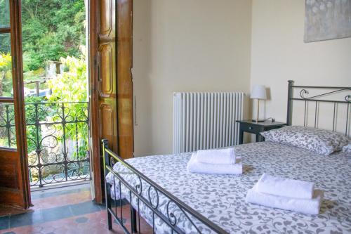 a bedroom with a bed with two towels on it at Casa Liberty - WelcHome in Cannobio