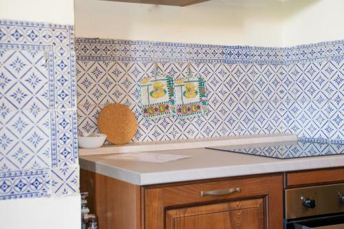 a kitchen with blue and white tiles on the wall at Casa Liberty - WelcHome in Cannobio