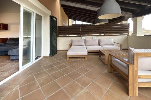 a patio with a couch and a table at LETS HOLIDAYS Luxury house in Cala Llevado in Tossa de Mar